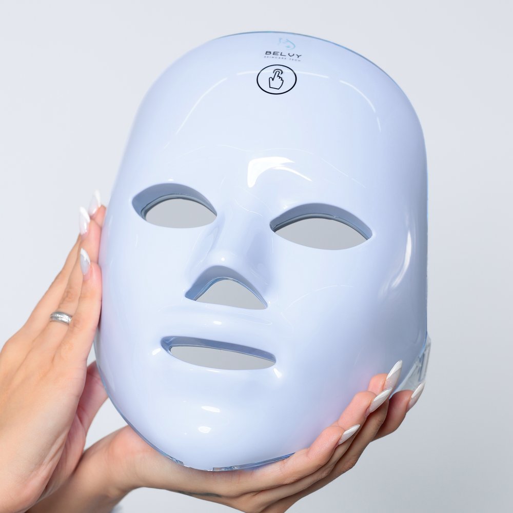 Máscara de LED facial Light Care segurada por duas mãos, mostrando o formato anatômico que cobre o rosto inteiro