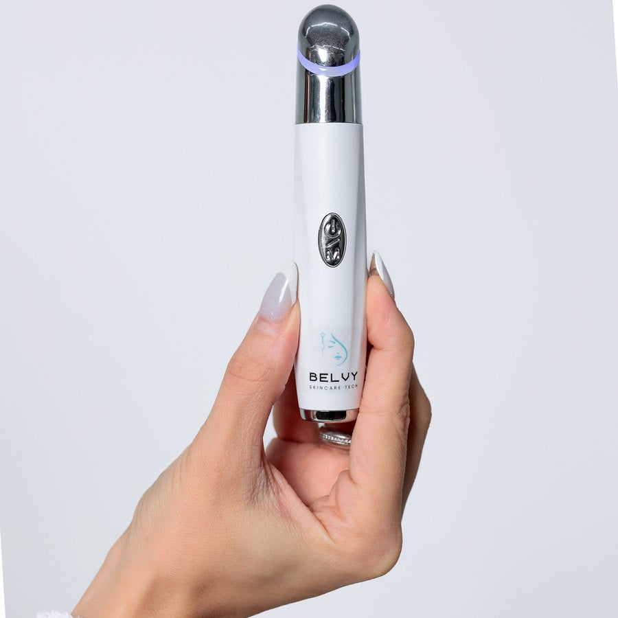 Massageador facial Eye Revive segurado na mão, com a ponta de aço inoxidável acesa